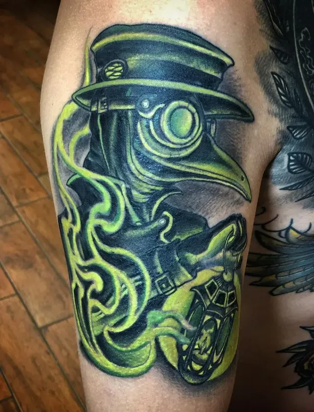 Color tattoo of a plague doctor with green tones and roses on a client's thigh, tattooed at TBA Tattoos in West Palm Beach