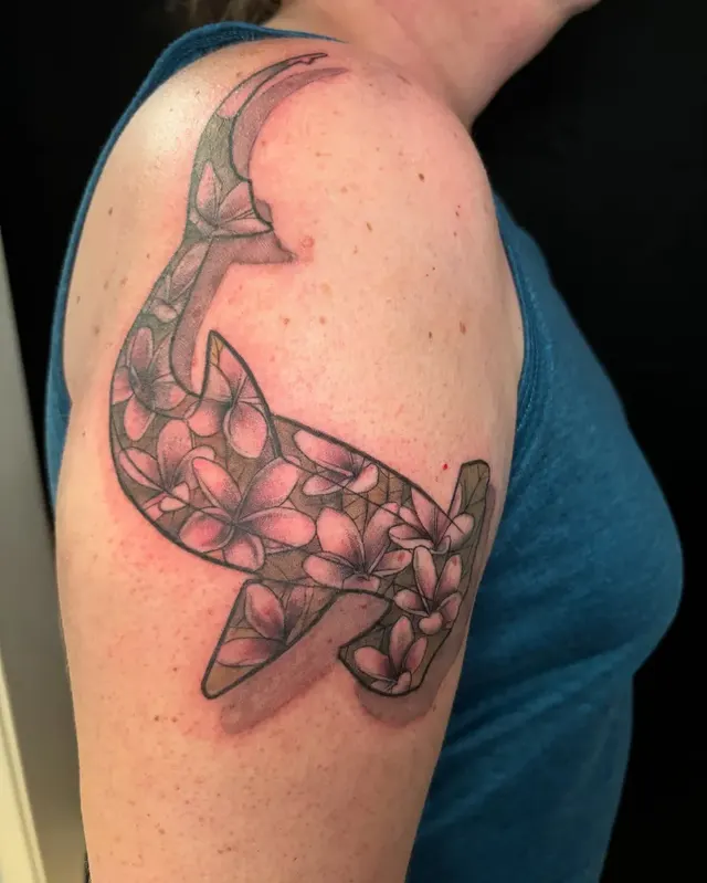 Color tattoo of a hammerhead shark with flowers and a banner on a client's shoulder, tattooed at TBA Tattoos in West Palm Beach
