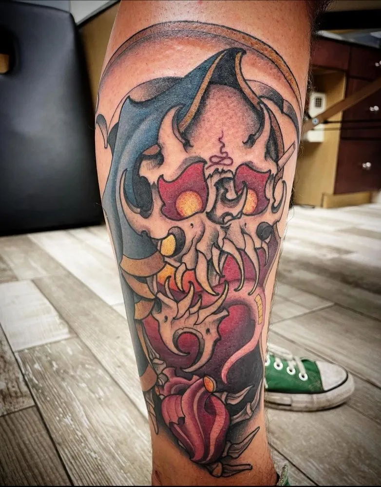 Neo-traditional color tattoo of a horned skull mask on a client's calf, tattooed at TBA Tattoos in West Palm Beach